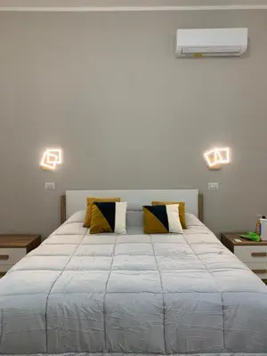 a bedroom with a large white bed with yellow pillows at Casa di Azzurra in Rome