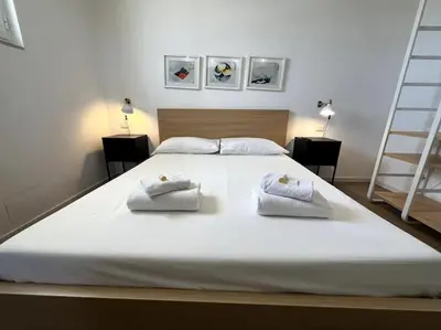 a large white bed with two towels on it at Trastevere Penthouse in Rome