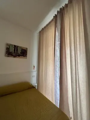 a bedroom with a bed and a window with curtains at Don sweet home- Hedi 101 in Rome