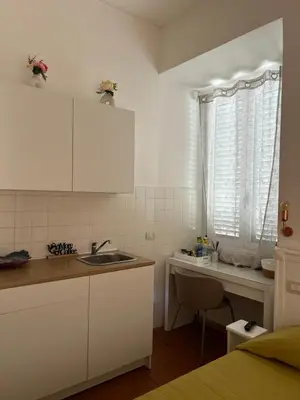 a kitchen with white cabinets and a sink and a desk at Don sweet home- Hedi 101 in Rome