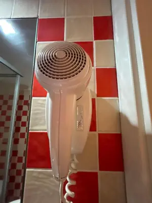 a white hairdryer on the wall of a bathroom at Don sweet home-Hedi in Rome