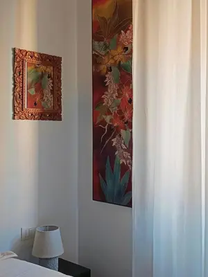a bedroom with a painting on the wall and a lamp at Un angolo di Oriente a due passi da San Pietro in Rome