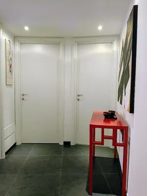 a room with two white doors and a red table at Un angolo di Oriente a due passi da San Pietro in Rome