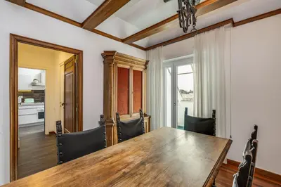 a dining room with a wooden table and chairs at Elegante appartamento 130mq in stile classico in Rome