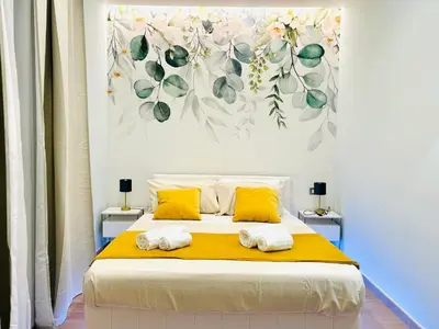 a bedroom with a large bed with yellow pillows at The Rooms of Wonders in Rome