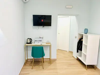 a room with a desk and a green chair at The Rooms of Wonders in Rome