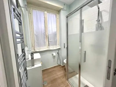 a bathroom with a shower and a toilet and a window at The Rooms of Wonders in Rome