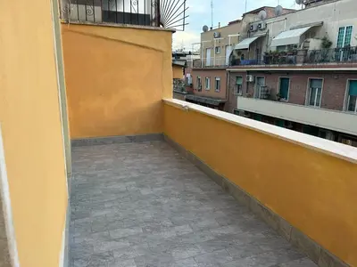 a balcony with a yellow wall and some buildings at The Rooms of Wonders in Rome