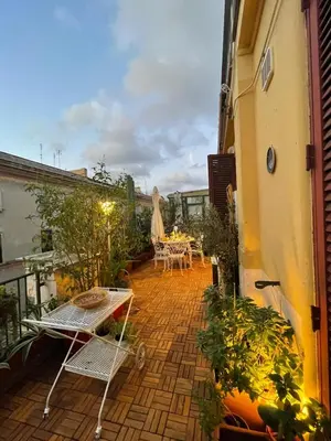 a patio with a table and chairs on a balcony at Terrace & 1930s Charm - Vatican Walk in Rome