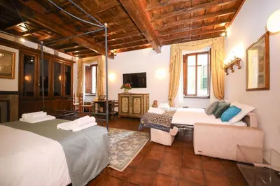 a hotel room with two beds and a living room at Domus Minelli Navona by GHOR in Rome