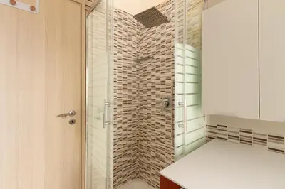 a shower with a glass door in a bathroom at Cozy Retreat Saint John in Rome