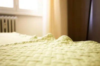 a close up of a white bed with a blanket at Cozy Retreat Saint John in Rome