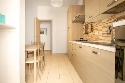 a kitchen with wooden cabinets and a table at Cozy Retreat Saint John in Rome