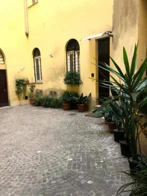 a courtyard with potted plants in front of a building at Charme Holidays Trastevere in Rome