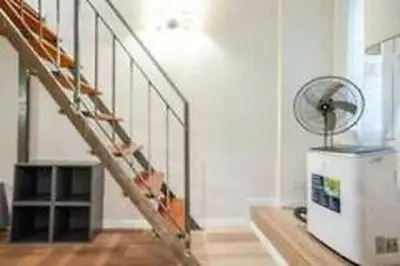 a room with a staircase with a fan and a table at Charme Holidays Trastevere in Rome