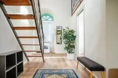 a hallway with a staircase and a couch and a rug at Charme Holidays Trastevere in Rome