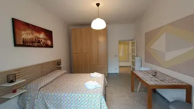 a small bedroom with a bed and a table at Galaxia Home in Rome