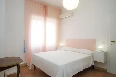 a bedroom with a white bed and a table at Oasi urbana - The Vatican Roof Garden in Rome