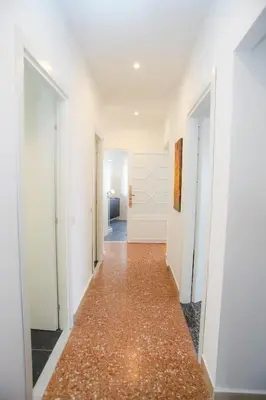 a hallway with white walls and a red floor at Oasi urbana - The Vatican Roof Garden in Rome