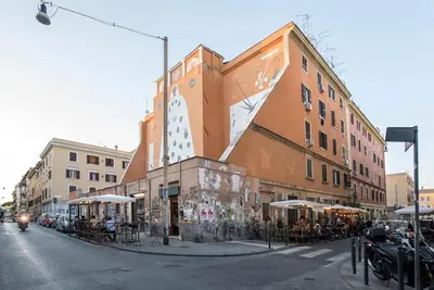 a building on a city street with tables and umbrellas at Urban Oasis near Termini with Patio, int1b in Rome