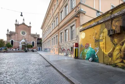 an empty street with a building with graffiti on it at Urban Oasis near Termini with Patio, int1b in Rome