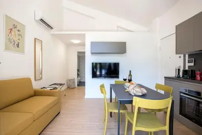 a kitchen and living room with a table and yellow chairs at Urban Oasis near Termini with Patio, int1b in Rome