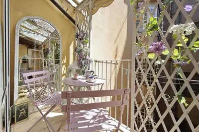 a small table and chairs on a balcony with flowers at Luxury Navona apartments by Flatinrome in Rome