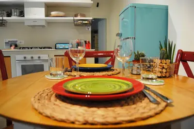 a table with a plate and wine glasses on it at Alloggio Appio Claudio con Corte Esclusiva I Metro A in Rome