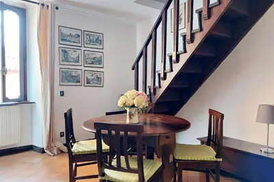a dining room table with a vase of flowers on it at St.Margherita Charming House in Rome