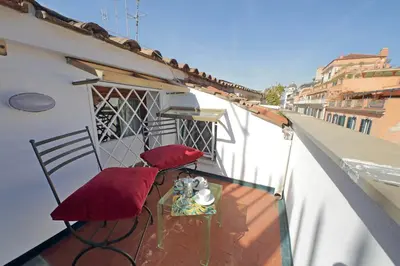 a balcony with two red chairs and a table at Lovely Apartment Via Sistina in Rome