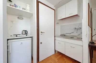 a kitchen with white cabinets and a sink at Lovely Apartment Via Sistina in Rome
