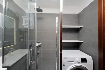 a bathroom with a washing machine and a sink at Lovely Apartment Via Sistina in Rome