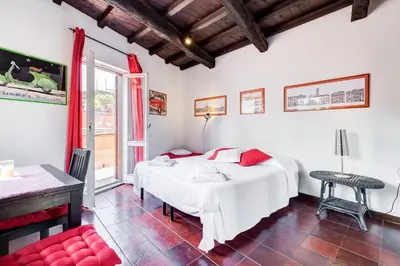 a bedroom with two beds and a table and a window at Romantic house with terrace in Rome