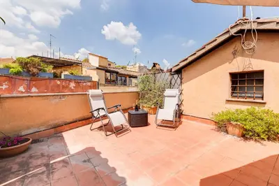 a patio with two chairs on top of a building at Romantic house with terrace in Rome
