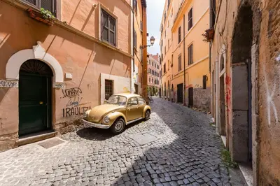 an old gold car parked on a cobblestone street at Romantic house with terrace in Rome
