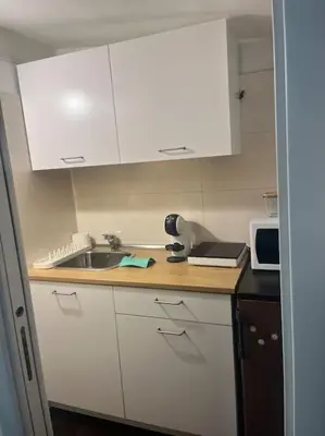a kitchen with white cabinets and a sink and a microwave at Notte tra le stelle in Rome