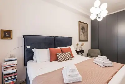 a bedroom with a large bed with a black headboard at Vatican Elegance House in Rome