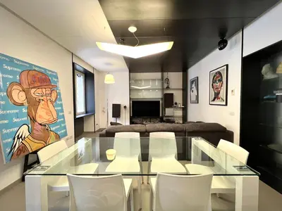 a dining room with a glass table and white chairs at Apuania 12 in Rome