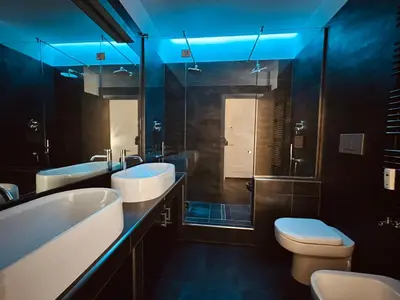 a bathroom with two sinks and a toilet and a blue light at Apuania 12 in Rome