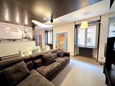 a living room with a large couch and a kitchen at Apuania 12 in Rome