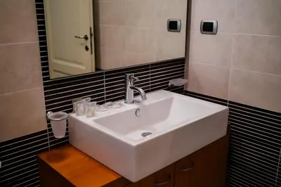 a bathroom with a white sink and a mirror at 5 Min From Trastevere Rome Chic Apartment in Rome
