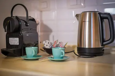 a coffee pot and two cups on a counter at ht m&n bilo colosseo in Rome
