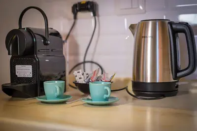 two cups on a counter next to a coffee pot at ht m&n bilo colosseo in Rome