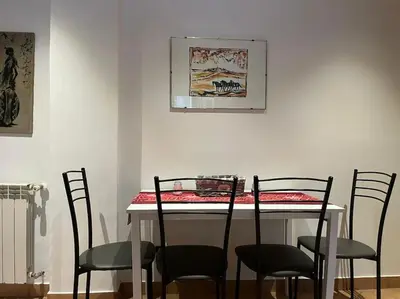 a dining room table with four chairs and a table with a red at La Dolce Vita - Casa Mì in Rome