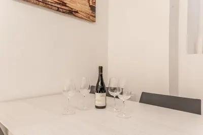 a table with a bottle of wine and four wine glasses at Casa Vaticano di Simone&Alessio in Rome