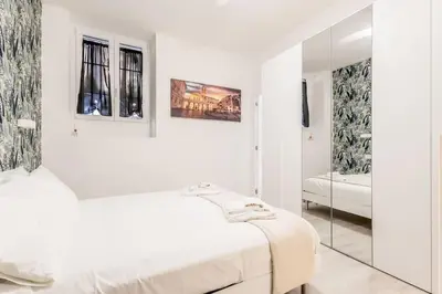 a white room with a bed and a mirror at Casa Vaticano di Simone&Alessio in Rome
