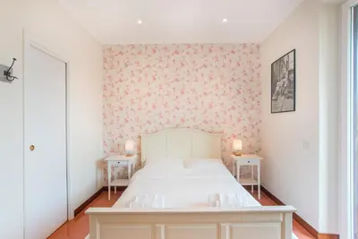 a bedroom with a white bed and two tables at Casa di Alice in Rome