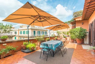 a table and chairs with an umbrella on a patio at Casa di Alice in Rome