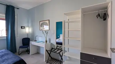 a bedroom with a bed and a desk and a bedroom with a bed at Nuova Casa Elena a Montesacro in Rome