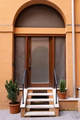 a staircase leading to a door with two potted plants at NEW Mini Loft per 5 a Roma centro in Rome